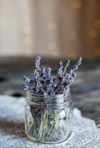 A small glass jar with lavender sprigs inside.